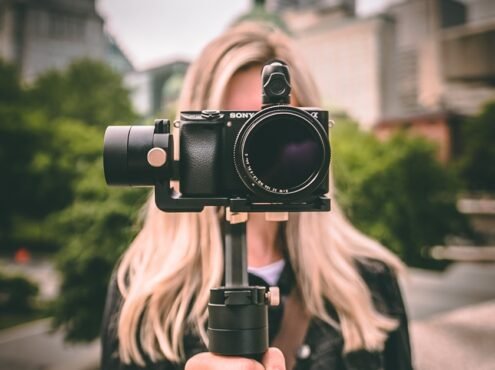selective focus photography of woman holding camera gimbal